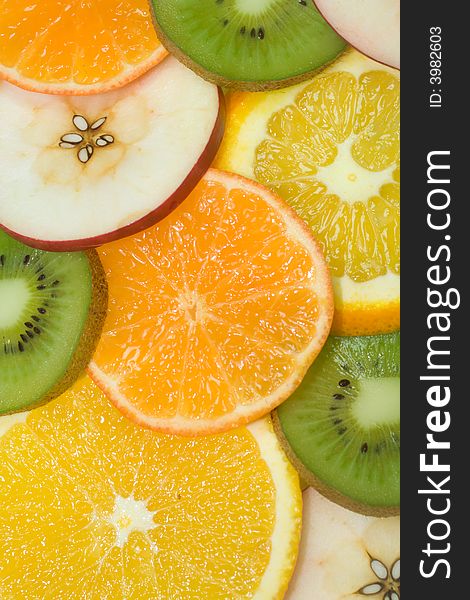 Fruits background from slices kiwi, apple, tangerine and orange