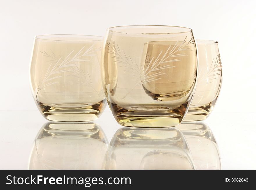 A glass beside a stack of white plates - on white background. A glass beside a stack of white plates - on white background