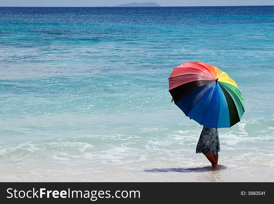 Girl with umbrella on coastline