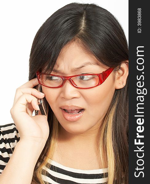 A woman wearing red eyeglasses talking on the phone. A woman wearing red eyeglasses talking on the phone