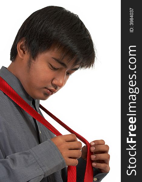 A man putting on a red necktie over a white background. A man putting on a red necktie over a white background