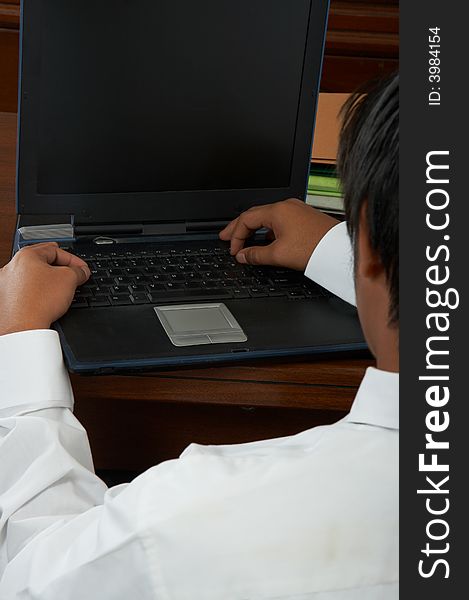 A close-up shot of a man working on his laptop. A close-up shot of a man working on his laptop