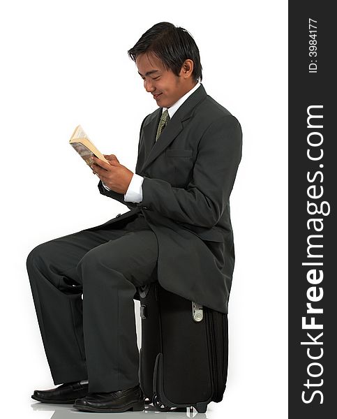 A man sitting on his luggage over a white background. A man sitting on his luggage over a white background