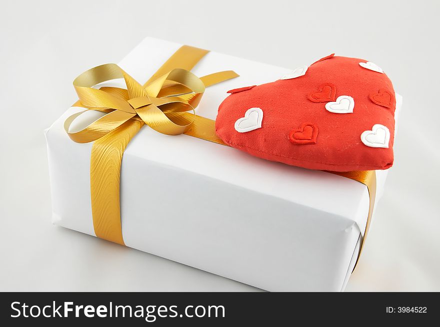 Box with a gift, tied up by a tape with a bow. A gift on Valentine's day