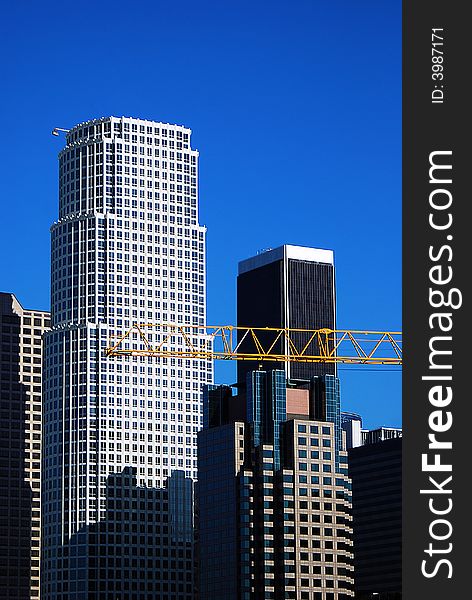 A construction crane is busy at work on a beautiful clear sunny day in downtown Los Angeles, California. A construction crane is busy at work on a beautiful clear sunny day in downtown Los Angeles, California.