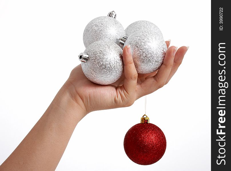 A hand holding some christmas tree decor. A hand holding some christmas tree decor