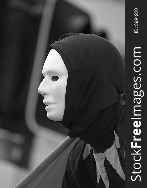A performing artist up close wearing a mask in black and white. A performing artist up close wearing a mask in black and white