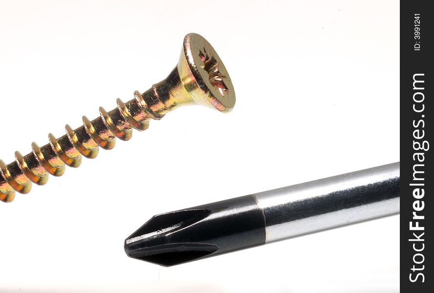 Close-up of cross head screwdriver and screw on white