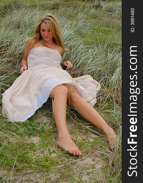 Beautiful girl on the beach Laying in the grass. Beautiful girl on the beach Laying in the grass