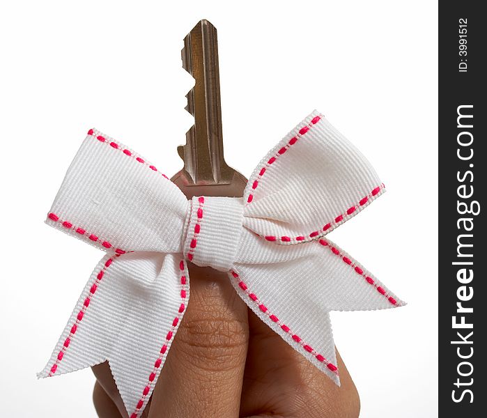 A hand with a ribbon holding a key