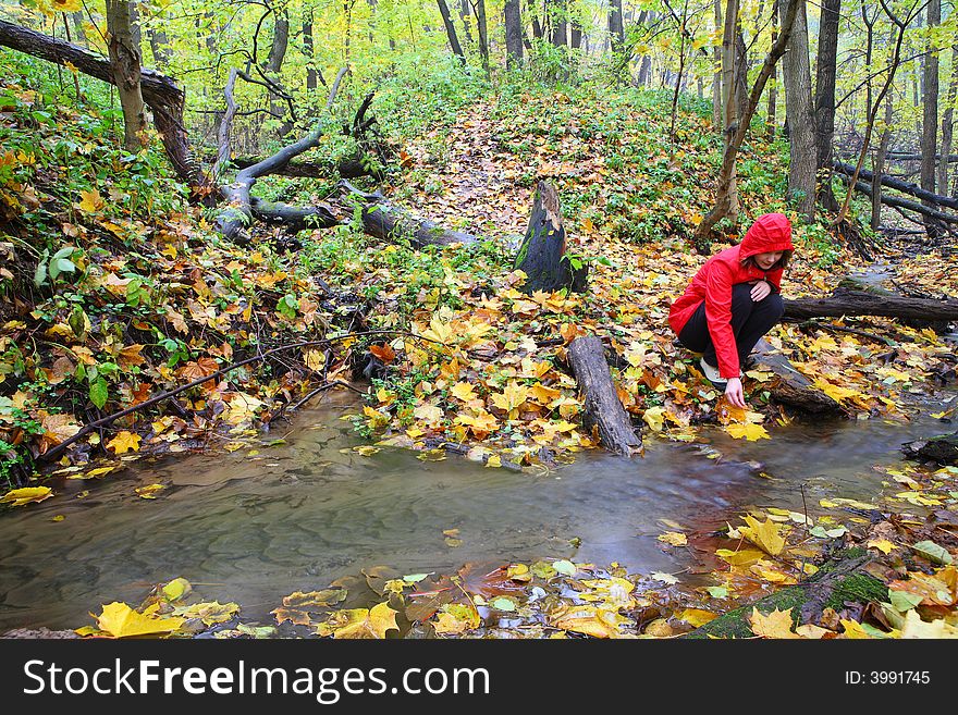 Autumn and lonely girl in red raincoat