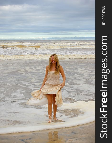 Beautiful girl at the beach walking and laughing in the water. Beautiful girl at the beach walking and laughing in the water