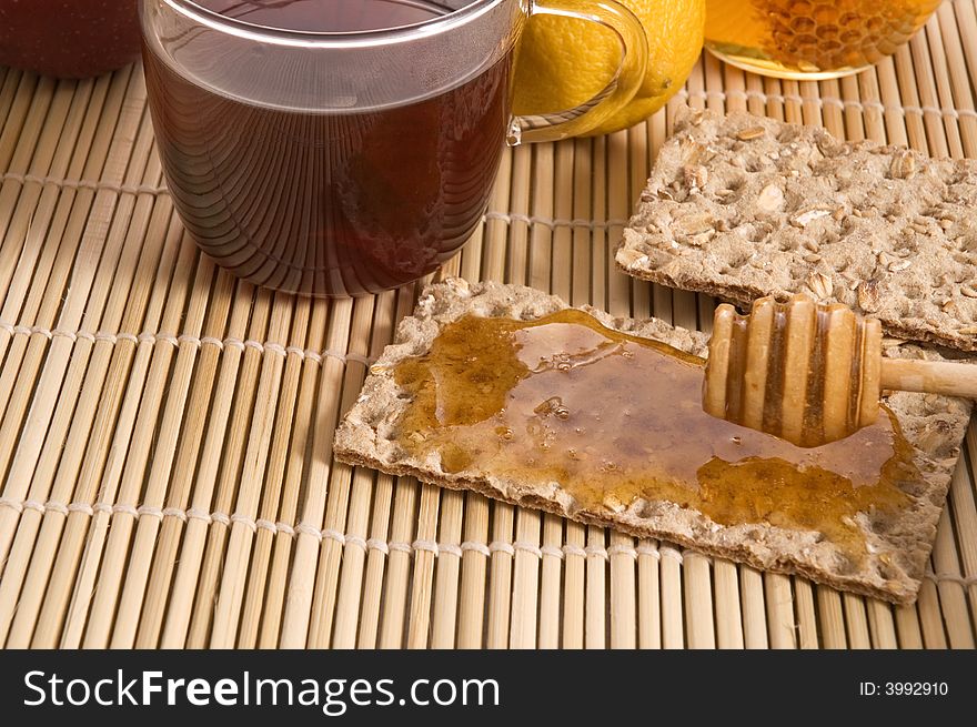 Sweet breakfast ingredients - bread, honey, fruits, tea. Sweet breakfast ingredients - bread, honey, fruits, tea
