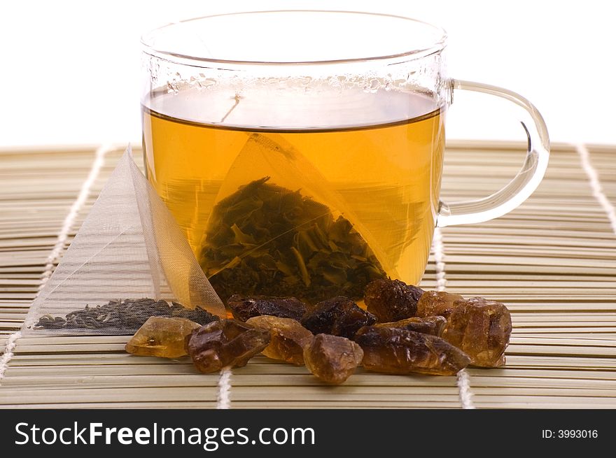 White tea, nylon tea-bag and golden sugar. White tea, nylon tea-bag and golden sugar