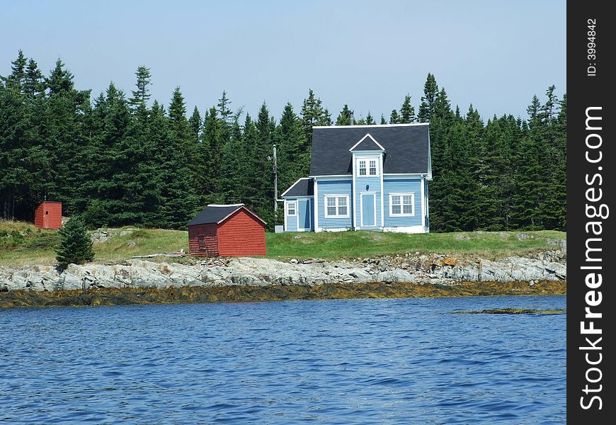 Blue house with white trim and a red shed on Outer Hirtle Island Lahave Lunenburg County Nova Scotia Canada. Blue house with white trim and a red shed on Outer Hirtle Island Lahave Lunenburg County Nova Scotia Canada