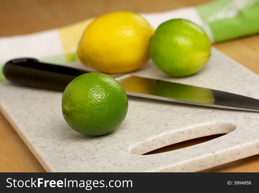 Limes, Lemon and Knife on Cutting Board