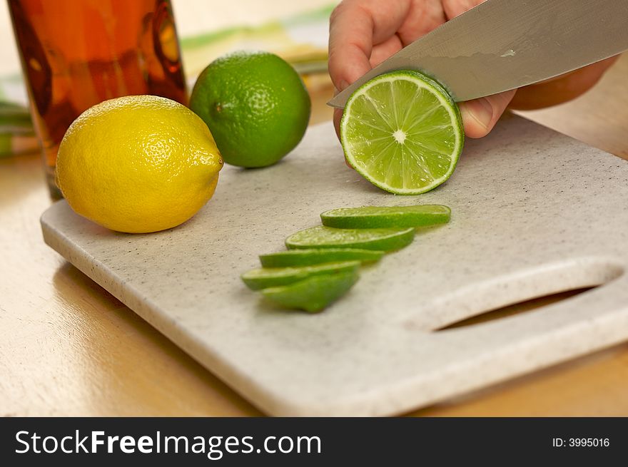 Slicing a lime on a cutting board.