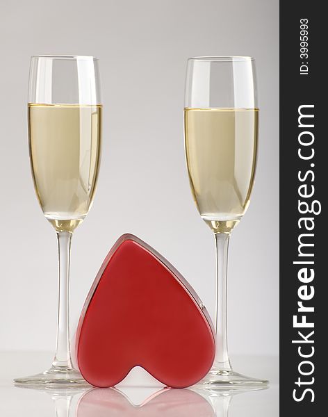 Two glasses of champagne with red heart in the middle. Two glasses of champagne with red heart in the middle