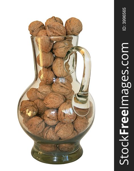 Handful of walnuts in a glass decanter on a white background