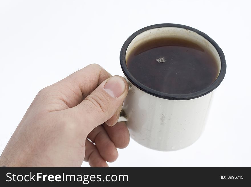 Cup of tea in human hand with white snow on the background