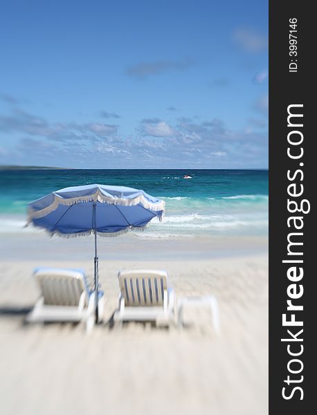 Two beach chairs  and umbrella on beautiful sunny day photographed with lensbaby. Two beach chairs  and umbrella on beautiful sunny day photographed with lensbaby