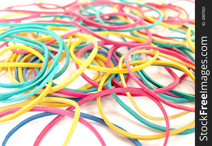 Close up of multi-colored rubber bands on white background