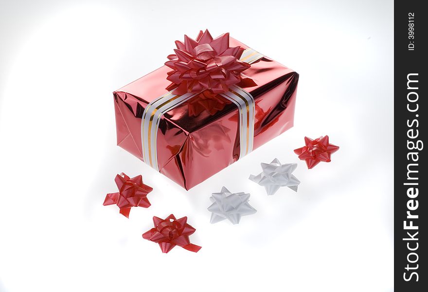 Red gift box with a white ribbon and paper flowers isolated on a white background. Red gift box with a white ribbon and paper flowers isolated on a white background.