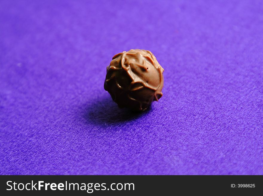 Fancy globe chocolate over a violet background with interesting lighting and shadow. Fancy globe chocolate over a violet background with interesting lighting and shadow.