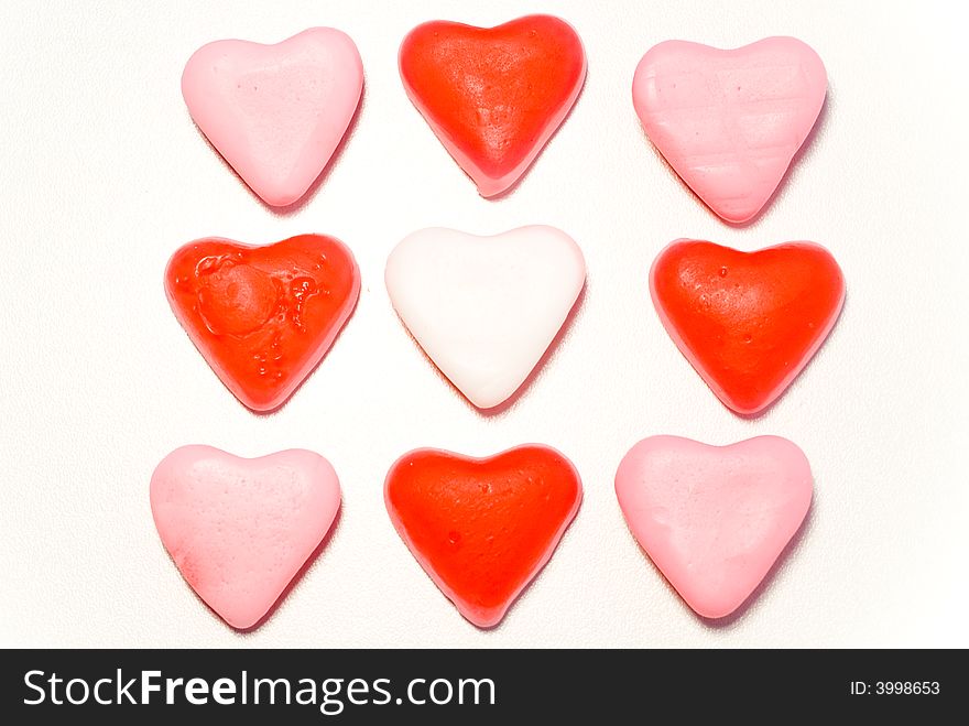 Close up red and pink candy hearts in square isolated on white