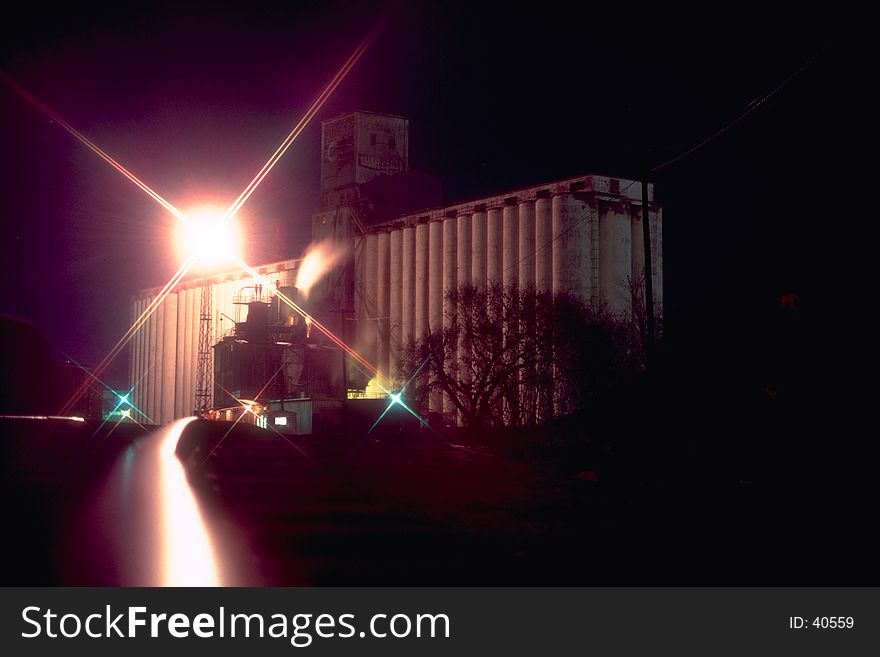 Grain Silos at night with tracks in foreground