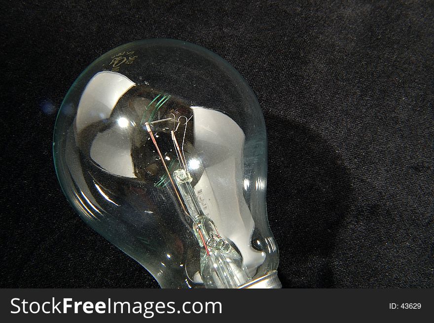 Closeup of an ordinary incandescent light bulb offline. Black background, highly detailed. Little lens flare, which in this case adds to the feeling in my opinion.