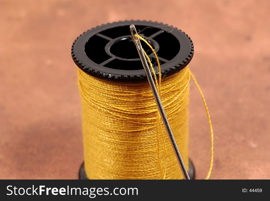 Photo of a Threaded Needle and Spool of Thread.