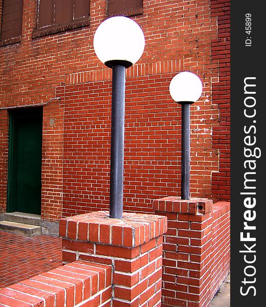 Old brick buildings and courtyard entrance guarded by two lamp posts. Old brick buildings and courtyard entrance guarded by two lamp posts.