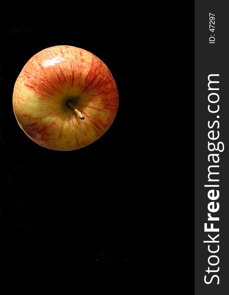 Top of a red yellow apple on a black background. Top of a red yellow apple on a black background