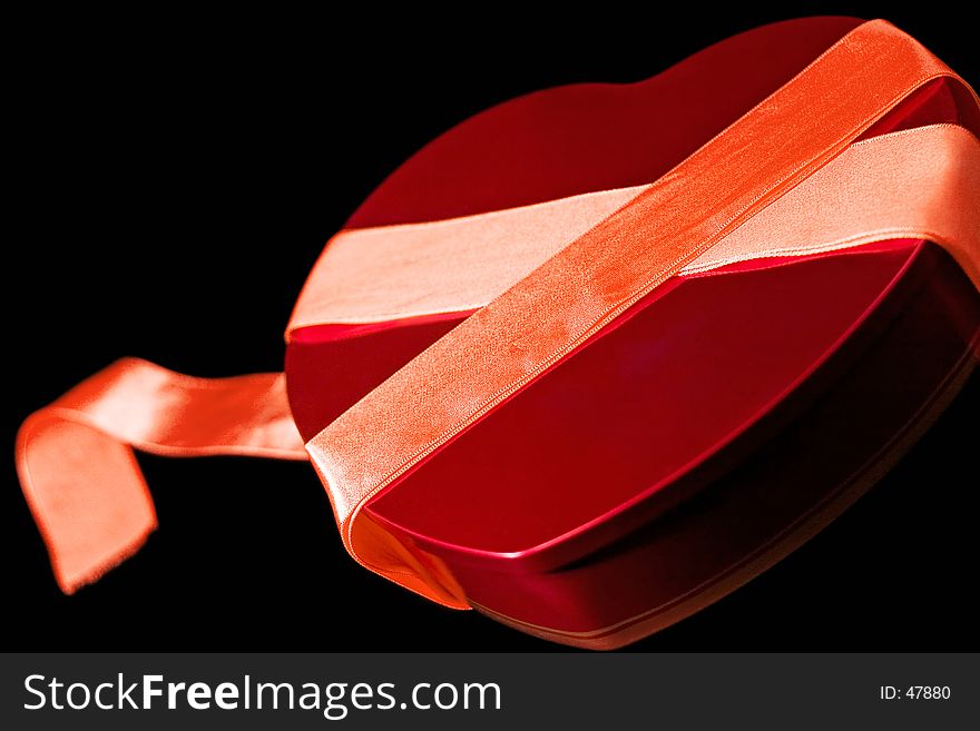 Heart shaped boxed wrapped with red ribbon. Heart shaped boxed wrapped with red ribbon