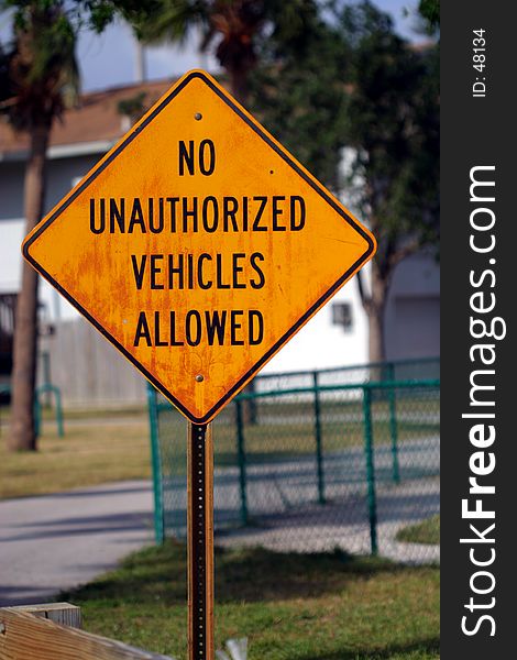 A sign stating that no unauthorized vehicles are allowed beyond this point. The sign has been in place for quite some time.