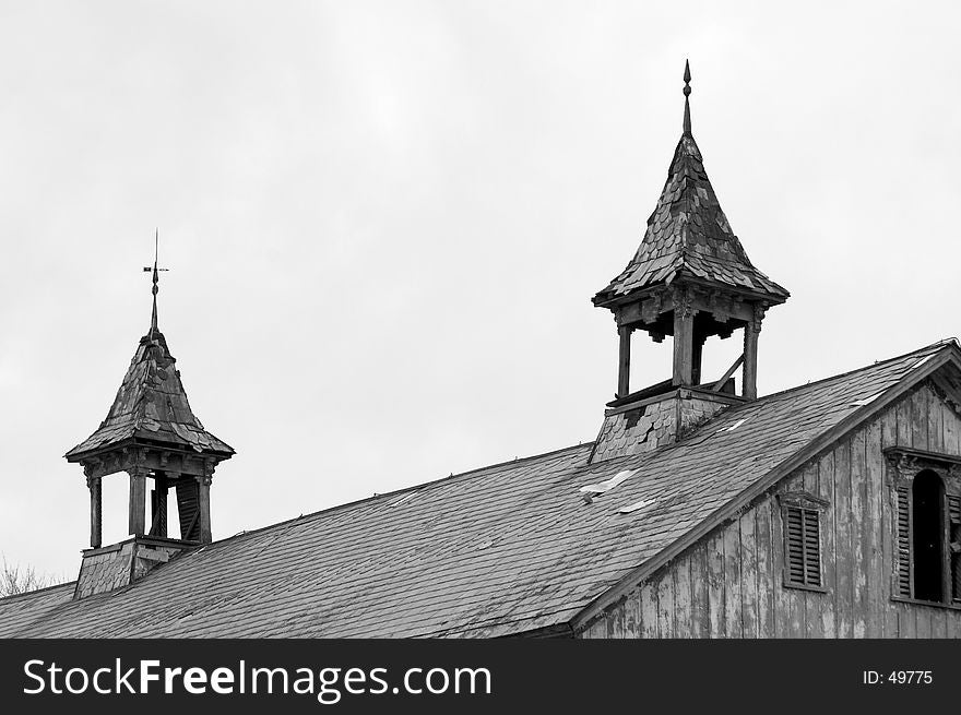 A pair of steeples on the roof of an old barn show the signs of age. photographed in Black and White. A pair of steeples on the roof of an old barn show the signs of age. photographed in Black and White