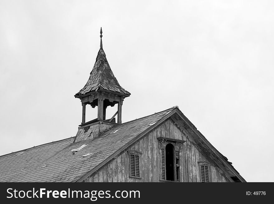 An old steeple on the roof of a barn shows the signs of age. Photographed in Black and White. An old steeple on the roof of a barn shows the signs of age. Photographed in Black and White