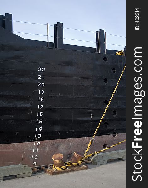 Port side of a freighter ship tied up to the dock in the harbor of Galveston, Texas, showing the depth marks on the freshly-painted side. Port side of a freighter ship tied up to the dock in the harbor of Galveston, Texas, showing the depth marks on the freshly-painted side.