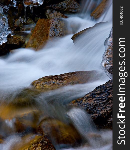 Water flows down from a mountain in early winter. Water flows down from a mountain in early winter.