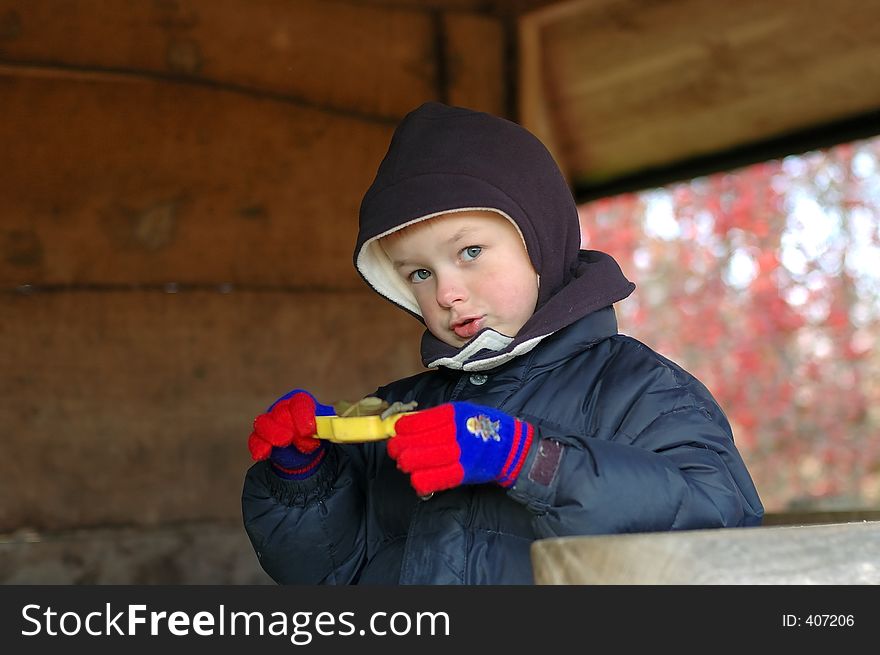 Boy child playing on playground in winter serving meal. Boy child playing on playground in winter serving meal