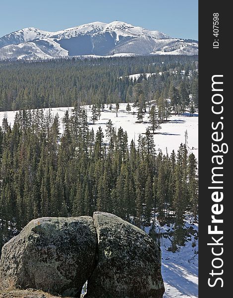 Bright winter landscape with snow covered mountain and prominent split boulder. Bright winter landscape with snow covered mountain and prominent split boulder.