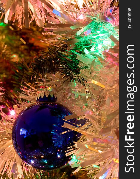 A blue Christmas tree ornament surrounded by garland. A blue Christmas tree ornament surrounded by garland.