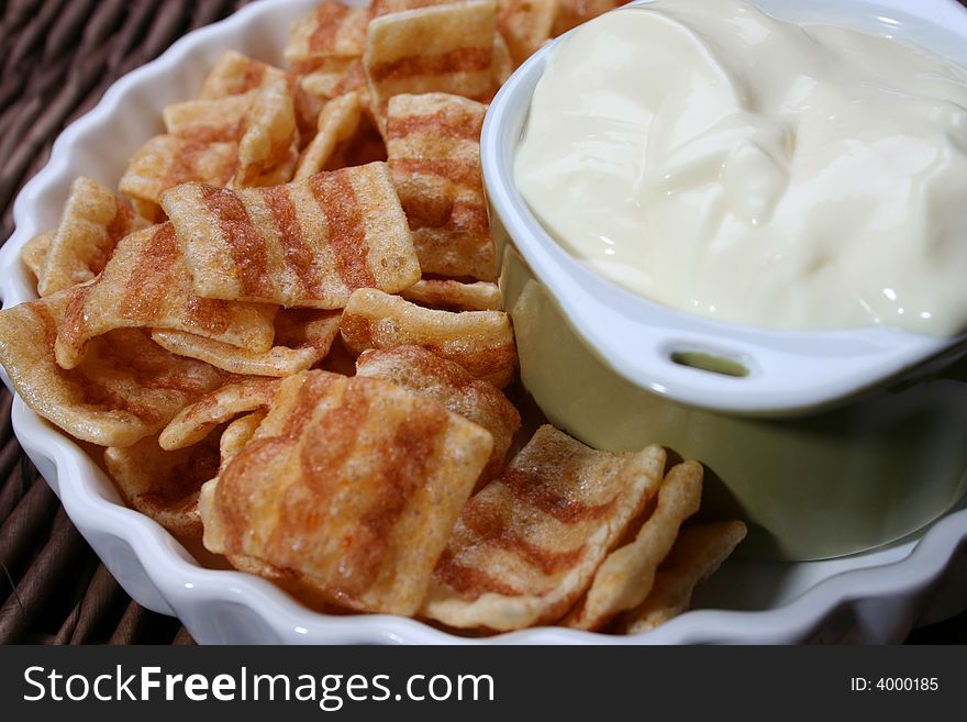 Chips in a white bowl with dip in a green bowl. Chips in a white bowl with dip in a green bowl