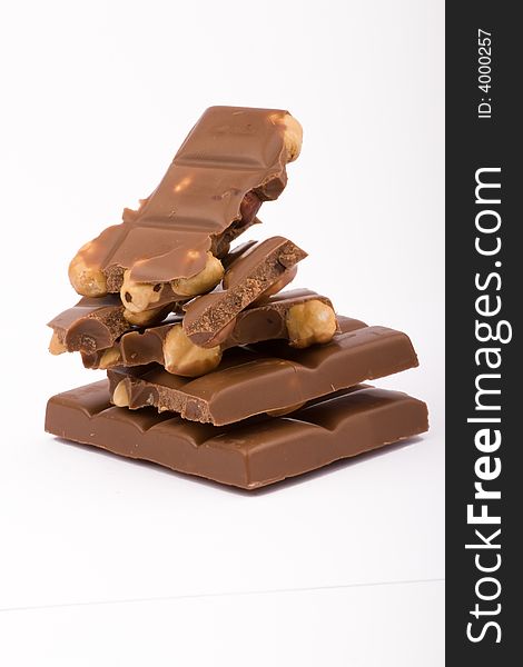 Chocolate blocks with hazelnuts isolated on white background