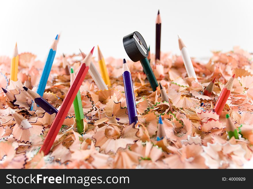 Colored pencils and pencil sharpener in white background