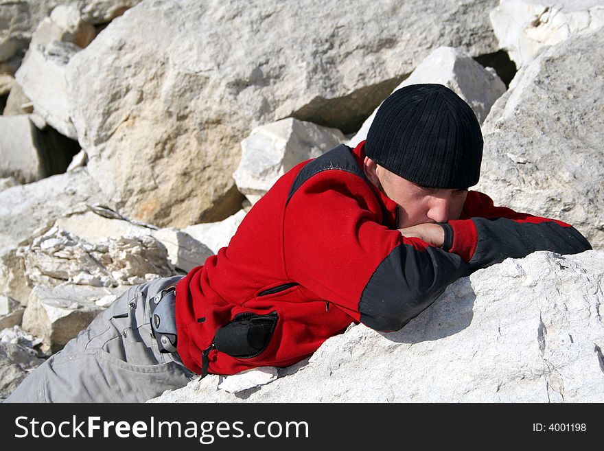 Thinking man in red blouse and black hat in a limestone quarry