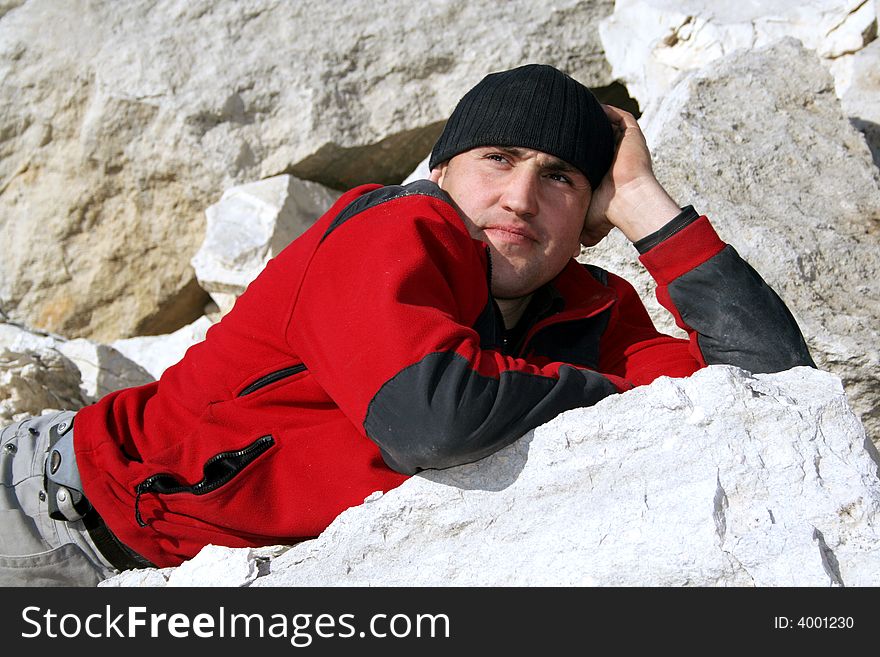 Thinking man in red blouse and black hat in a limestone quarry