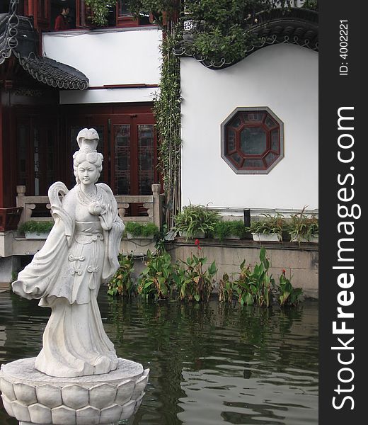 This image depicts a statue of a female in a Chinese garden. This image depicts a statue of a female in a Chinese garden.