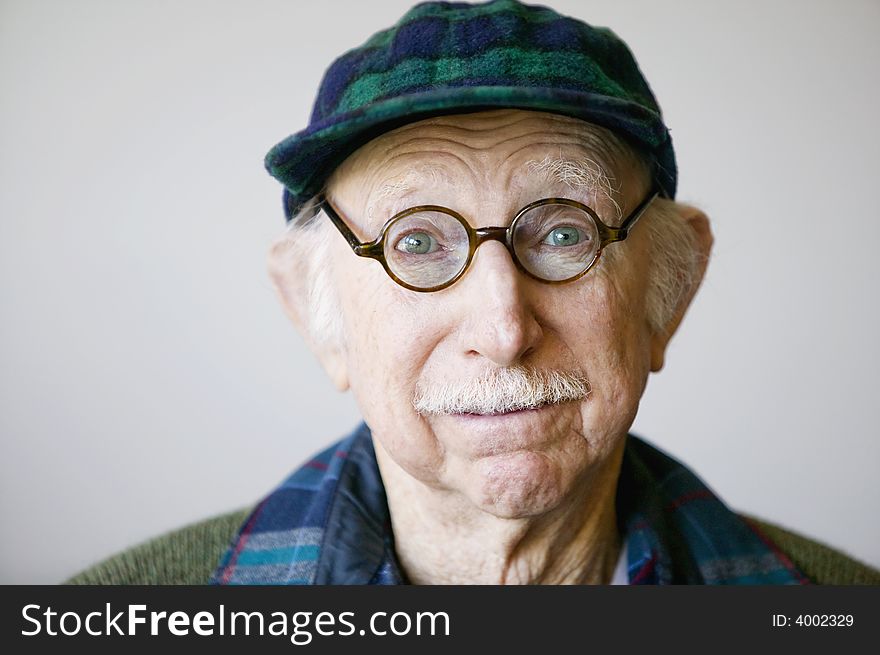 Portrait of a senior citizen wearing glasses and a sweater. Portrait of a senior citizen wearing glasses and a sweater.